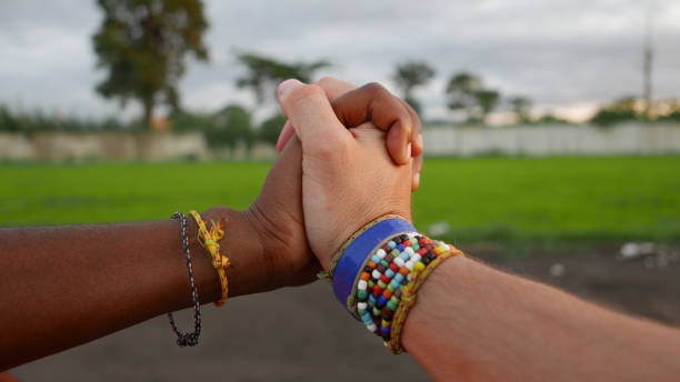 istock Black and white hands entwined 1207335471
