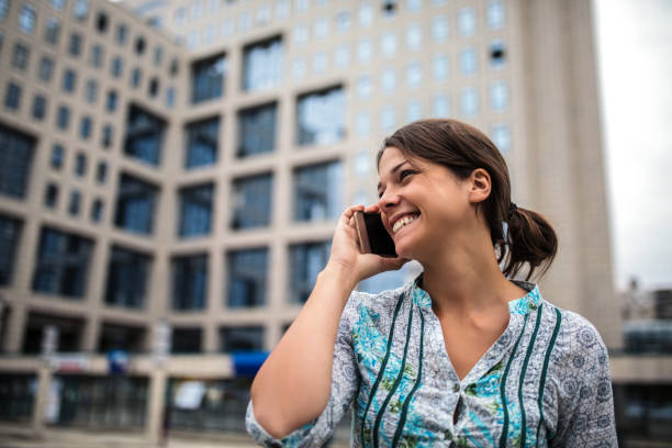 istock Woman using phone on city street 1207335680