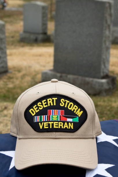 istock Desert Storm Veteran's Cap resting on an American Flag in a cemetery. 1207336067