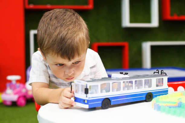 istock Cute boy playing with trolley car. Developing toys. 1207337133