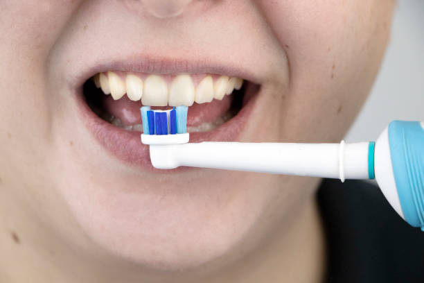 istock A man brushes his teeth with an electric brush while looking at the camera, as if looking in a mirror. Hygiene of the oral cavity 1207337266