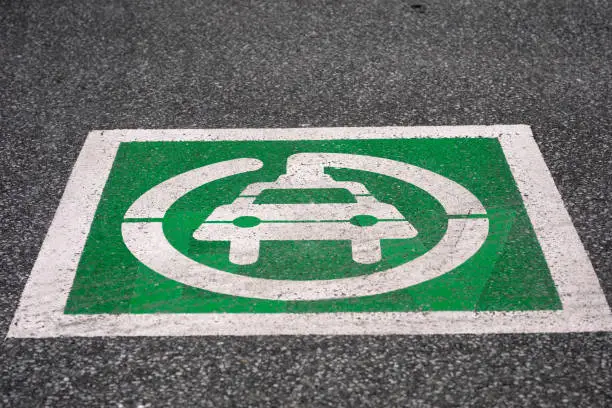 Electric vehicle EV charging station parking lot sign with symbol painted on road in Lasalle, Ontario Canada