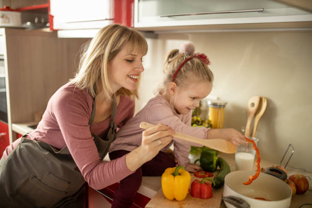 istock Mother and daughter preparing organic dinner 1207339899