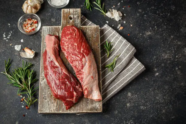 Photo of Raw beef steak with spices.