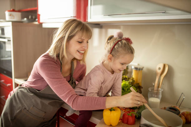 istock Mother and daughter preparing food in kitchen 1207341696