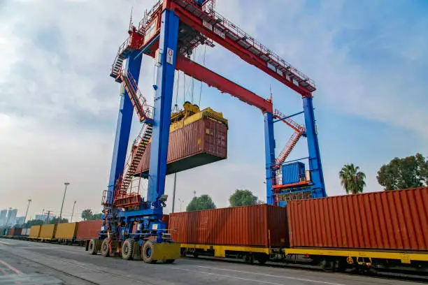 Photo of Cargo train platform with freight train container in a port for export logistics.