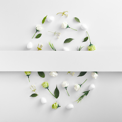 Spring herbs and flowers oval shaped composition on white background. Blooming buds and fresh green leaves, grass and foliage close up. Easter holiday rustic style decoration with botanical elements. White empty paper blank