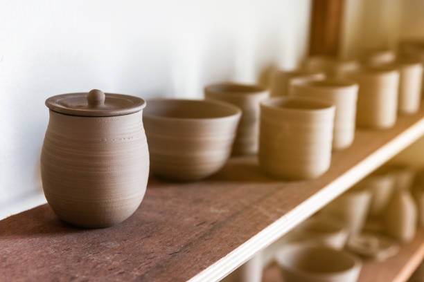 istock Close-up on Ceramic Cup with Lid on wooden display shelf for hand crafted Ceramic such as bowls, plates and cups. Creative workshop. 1207344028