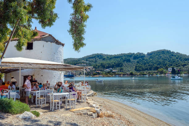 Skiathos, Greece - June 23 2017: Beautiful traditional tavern on the picturesque beach on Skiathos island, Greece. City Skiathos, with white authentic houses and beautiful nature stock photo