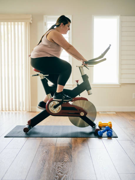 istock Woman Using Exercise Bike in a Home 1207347679