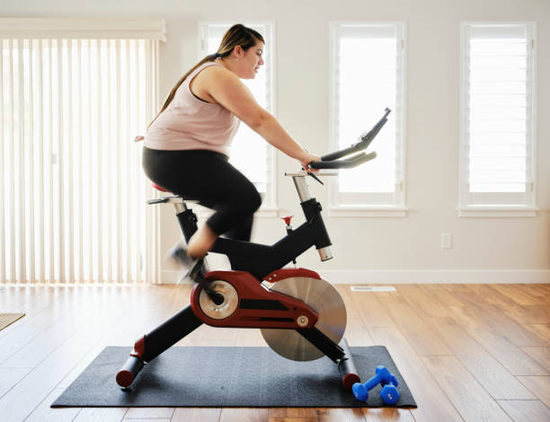 istock Woman Using Exercise Bike in a Home 1207349440