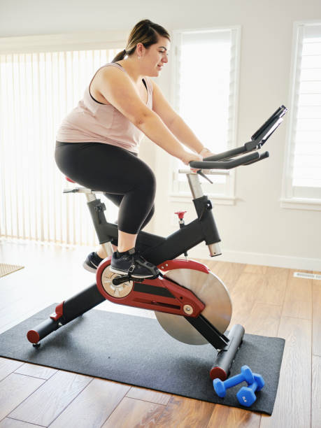 istock Woman Using Exercise Bike in a Home 1207349479