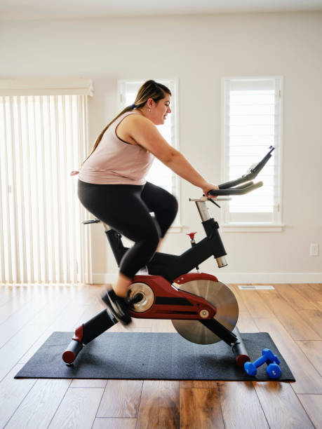istock Woman Using Exercise Bike in a Home 1207349550