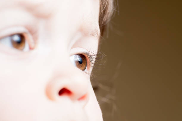 istock baby dark brown eyes close-up. Side look 1207350581