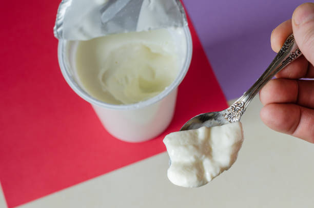 istock Spoon tasty yogurt in a man's hand. 1207351861