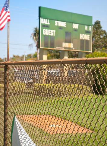 Baseball Field Scoreboard With American Flag And Chainlink Fencing