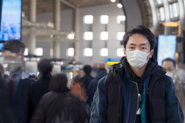 asiatischer mann trägt gesichtsmaske auf der straße - pollenkorn stock-fotos und bilder