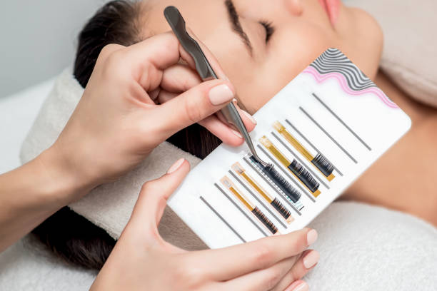 istock Beautician taking eyelashes by tweezers. 1207357984