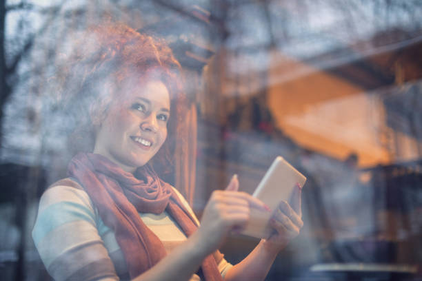 istock Woman sitting at a cafe and working on digital tablet 1207359017