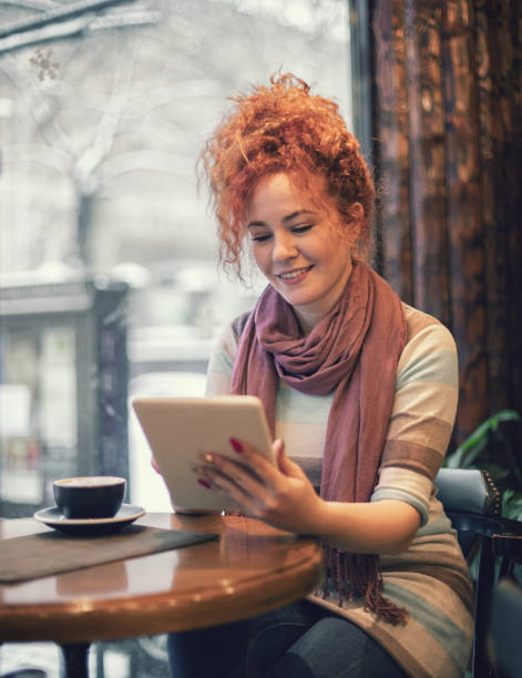 istock Woman sitting at a cafe and working on digital tablet 1207359018