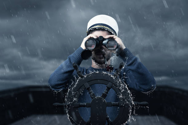istock helmsman with binoculars and cap viewing the coast and light tower in depth of field 1207364029