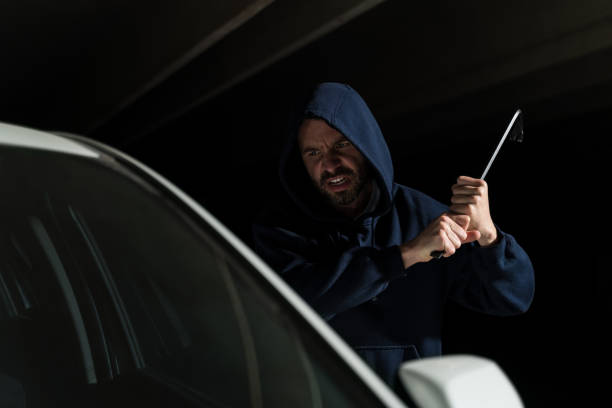 istock Male Burglar Using Metal Tool For Stealing Car 1207364190