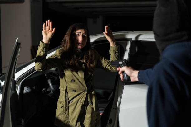 istock Robber Pointing Gun At Victim Disembarking From Car 1207364954