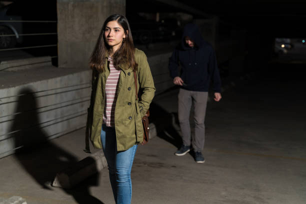 istock Robber Following Unaware Woman In Parking Lot 1207366016