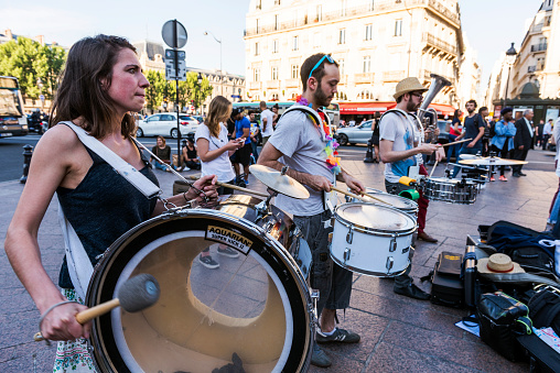 Paris, France - July 7, 2016: The bare brass band busking at Paris, France (Saint-Michel District). young musicians are playing some instrument and earning money by using classic musical instruments (trombone, saxophone, oboe, drums, tuba, horn) in street of Paris. They are street musicians.