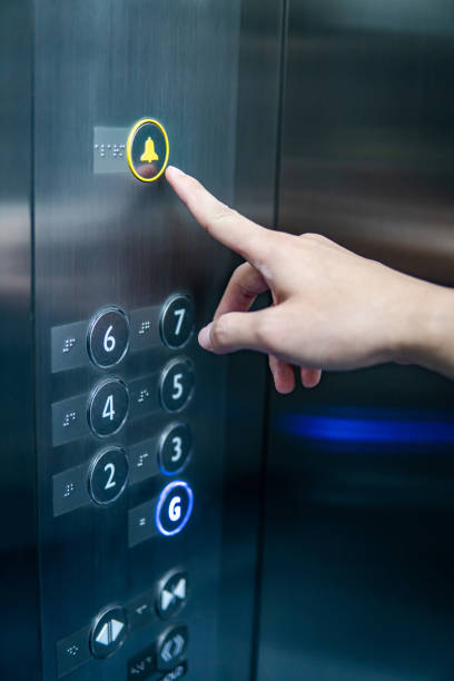 мужская рука нажатия на аварийную кнопку в лифте - elevator push button control panel moving up стоковые фото и изображения