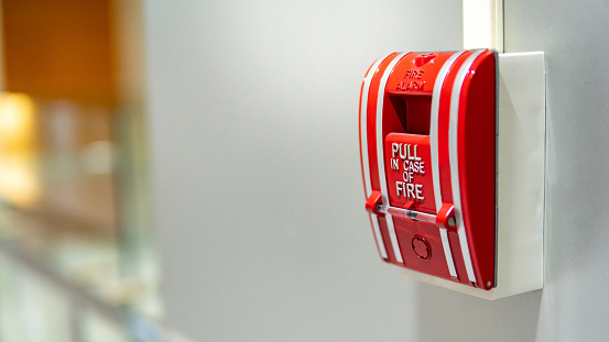 Urban details in Italian town: Fire extinguisher in underground parking lot garage