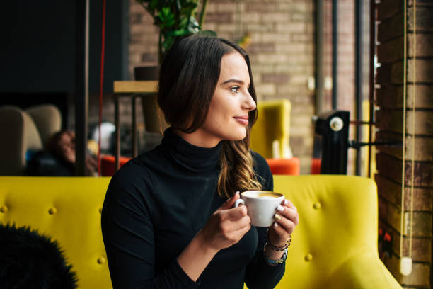 istock Stylish young woman drinking coffee at the cafe 1207372317