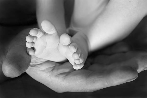 Father cradling babies feet stock photo