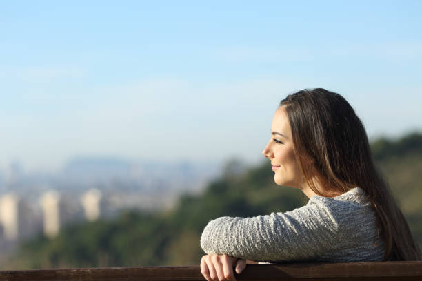 istock Satisfied woman contemplating views on a bench 1207374336