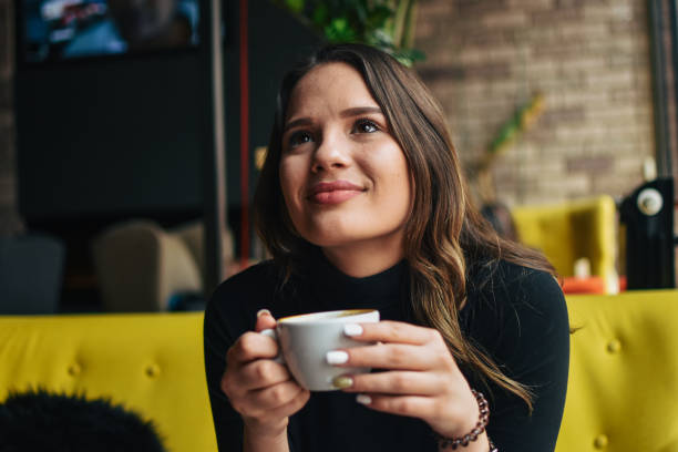 istock Stylish young woman drinking coffee at the cafe 1207374375