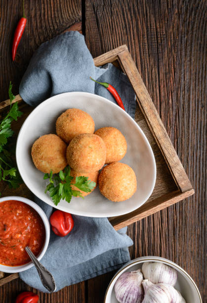istock Homemade classic Arancini Di Riso, crispy Sicilian rice balls stuffed with Mozzarella cheese, served with hot Arrabbiata dipping sauce 1207374549
