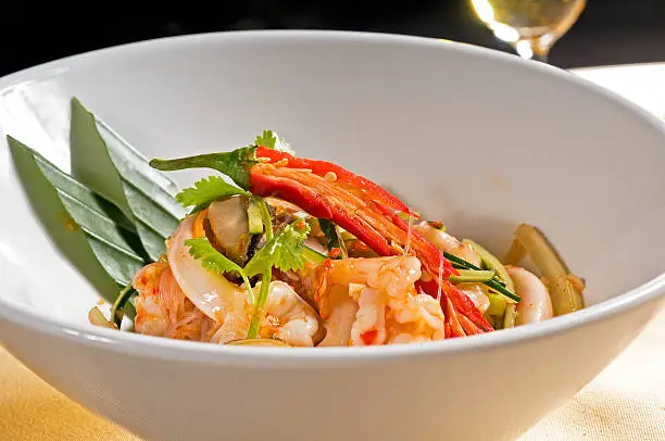 fresh seafood thai style salad with glass noodles on a bowl close up