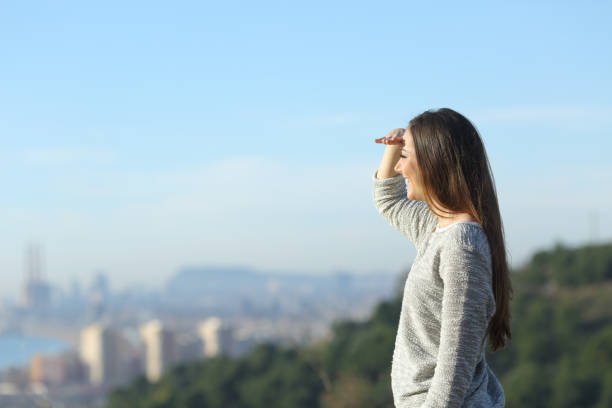 istock Happy woman looking at horizon protecting sight with hand 1207374735