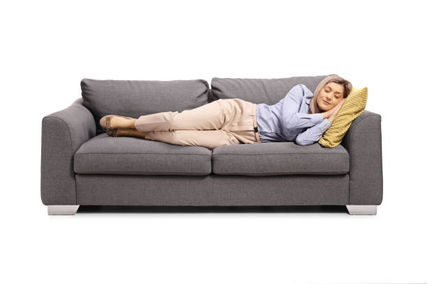 istock Young woman tired from work sleeping on a sofa 1207374739