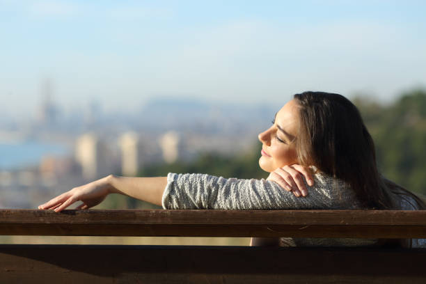 istock Woman resting napping on a bench in city outtskirts 1207374781