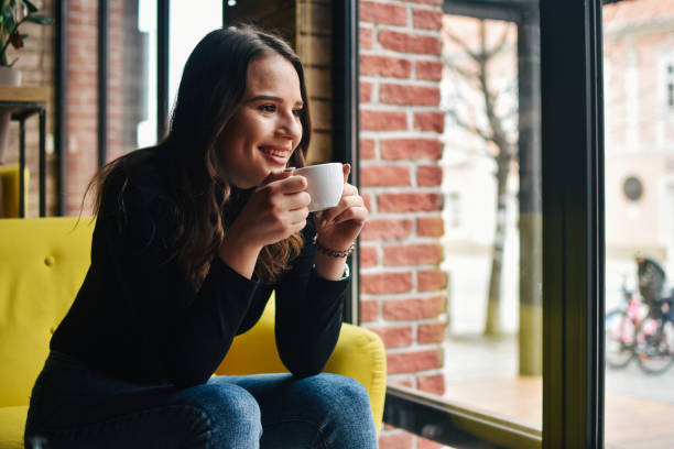 istock Stylish young woman drinking coffee at the cafe 1207374898