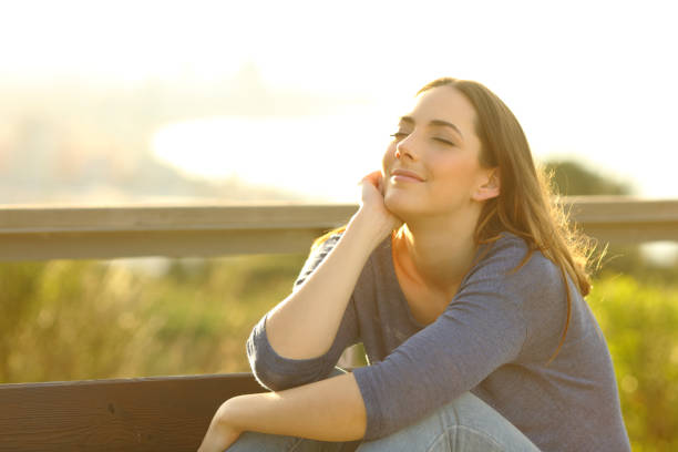 istock Woman relaxing sitting on a bench at sunset 1207375615