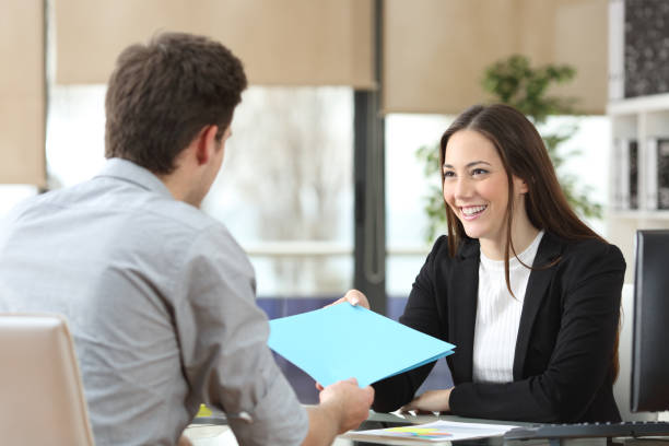 Employee giving folder to his manager during interview