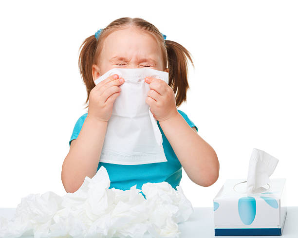 Little girl blows her nose stock photo