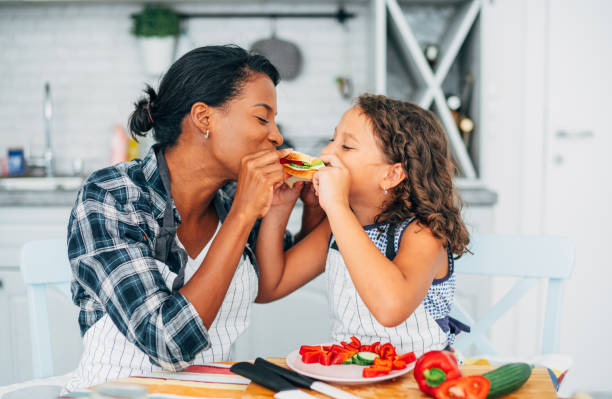 istock Mother and daughter eating sandwich together. 1207382413