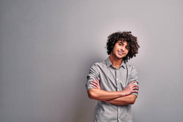 istock Isolated image of smiling eastern young man with crossed hands 1207384384