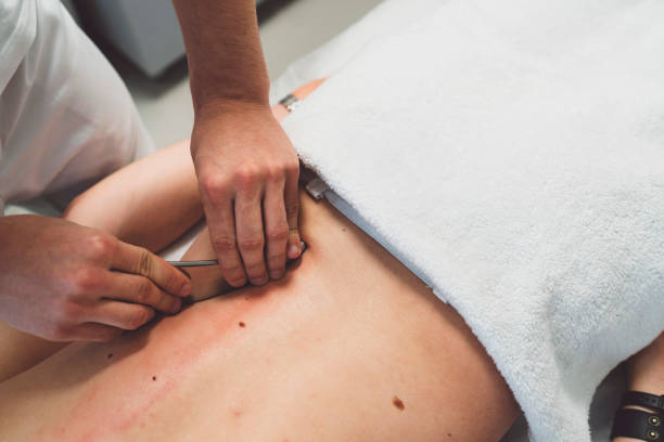 Physiotherapist, chiropractor giving a back massage to man patient. Osteopathy.
