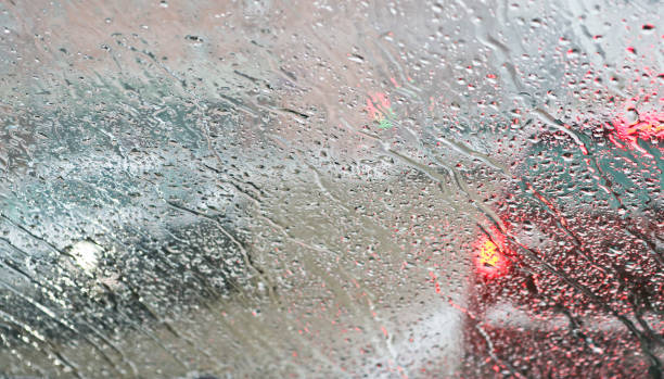 istock View from the car windscreen during rain and wet snow. Poor visibility while driving around the city. Snowy road. 1207385919