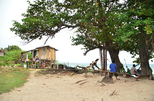Village resting outside their wooden house at Maliangin island that facing the sea at Borneo.