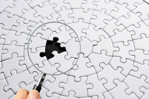 istock Search for missing last puzzle piece with magnifying glass 1207392191